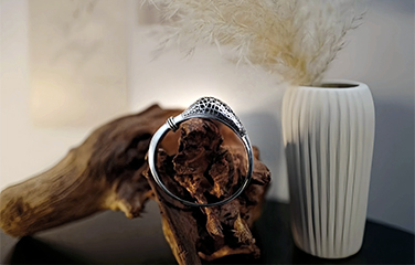 Openwork metal bracelet displayed on natural wood